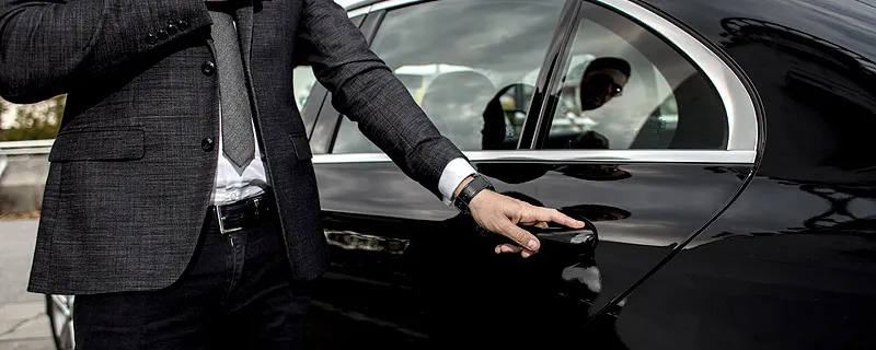 Professional Chauffeur Opening a Luxury Car Door for Client